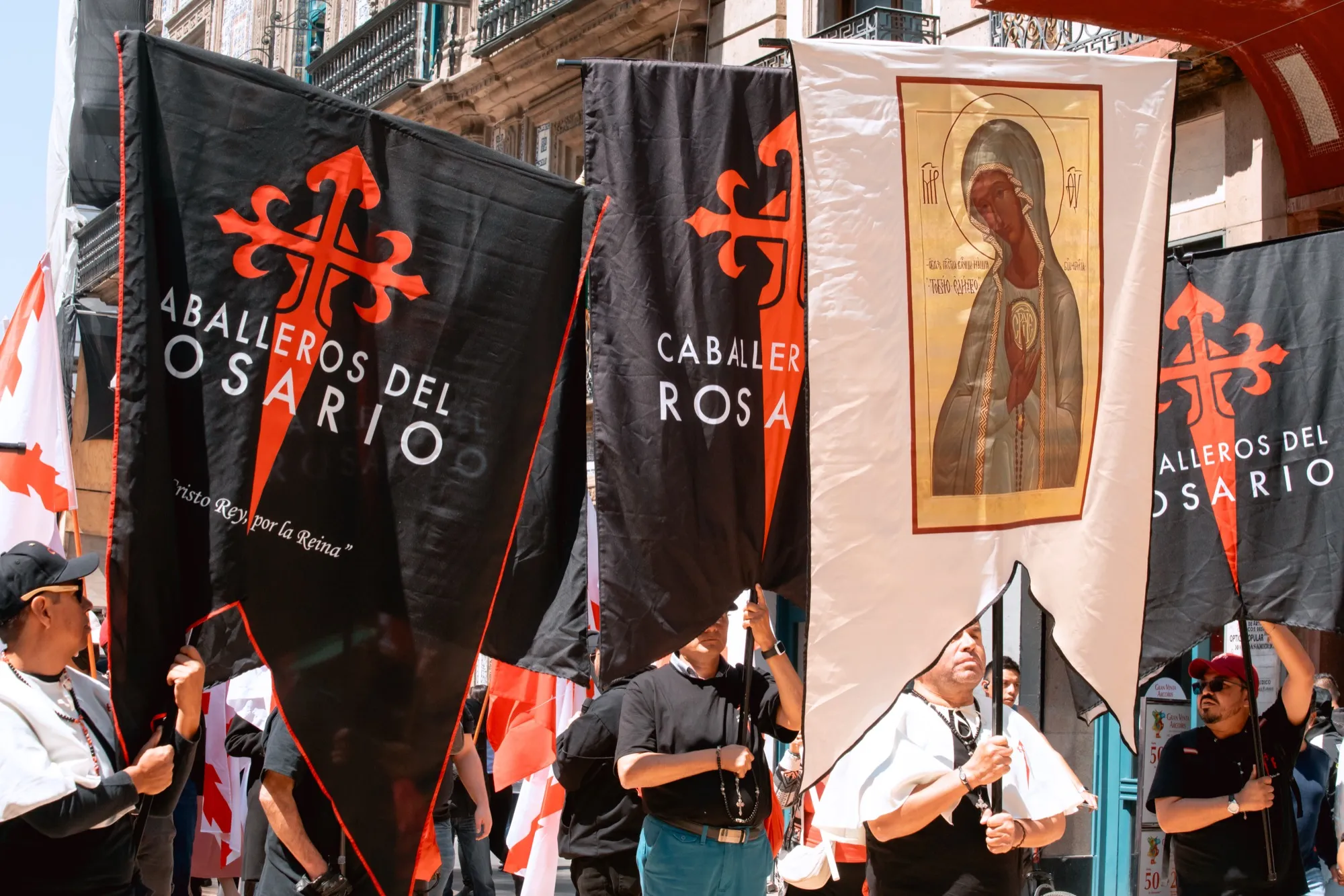 Un Chevalier de Chevaliers du Rosaire tient la croix de Saint-Jacques sur la place